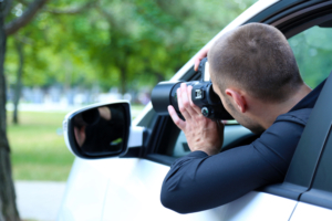 Private Investigator In Car A private investigator capturing evidence for their case from their car with a camera